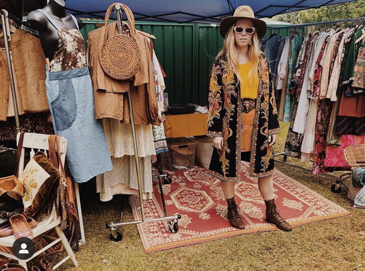 Vintage clothing rack featuring 60s and 70s boho fashion pieces from Sunflower Seed Vintage at a local market stall